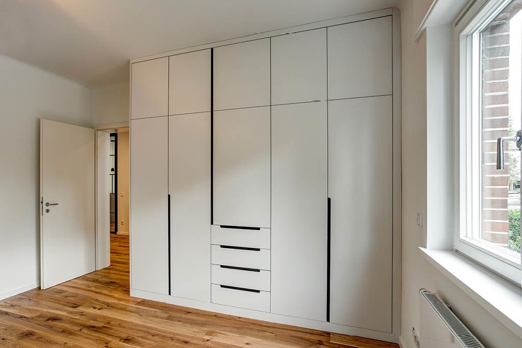 weißer Kleiderschrank Türen Schubladen Einbauschrank nach Maß mit schwarzer MDF-Platte HPL High Pressure Laminate vom Tischler Hamburg