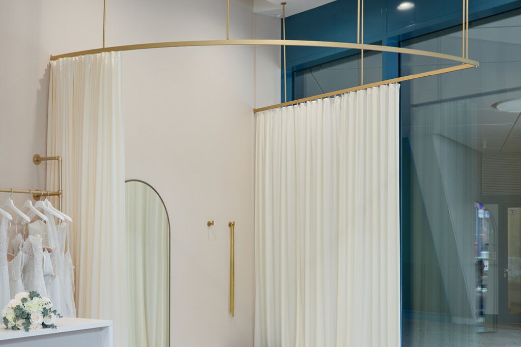Ladenbau Ladeneinrichtung Objektdesign Einzelhandel Umkleidekabine mit goldener Vorhangstange vom Tischler auf Maß Hamburg Holzmöbel